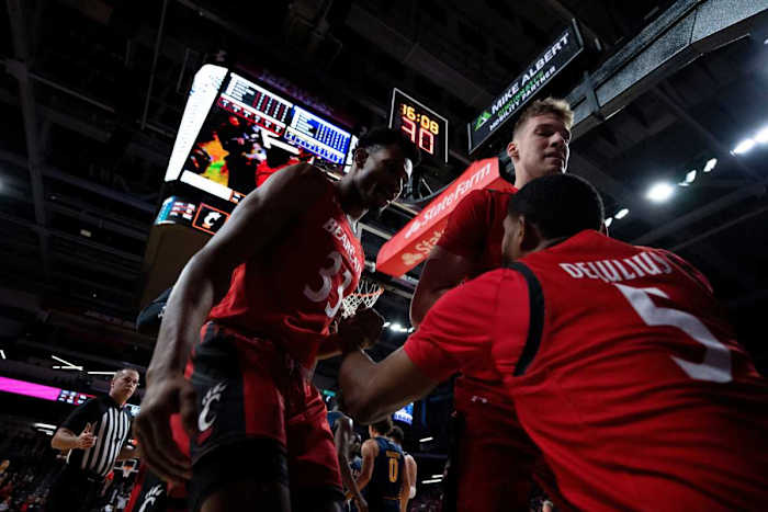 Cincinnati Bearcats forward Ody Oguama (33) and Cincinnati Bearcats forward Viktor Lakhin (30) help up Cincinnati Bearcats guard David DeJulius (5) after he was fouled while shooting in the first half of the NCAA men s basketball game between the Cincinnati Bearcats and the La Salle Explorers at Fifth Third Arena in Cincinnati on Saturday, Dec. 17, 2022. Ncaa Basketball La Salle Explorers At Cincinnati Bearcats Ac